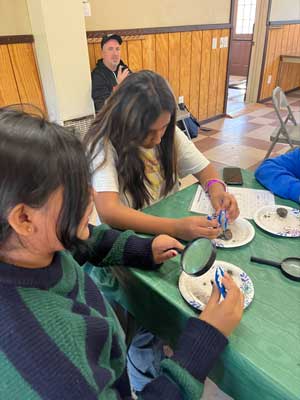 students looking at items through magnifying glasses