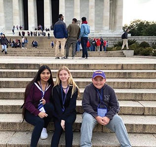Three students sitting on steps of the White House